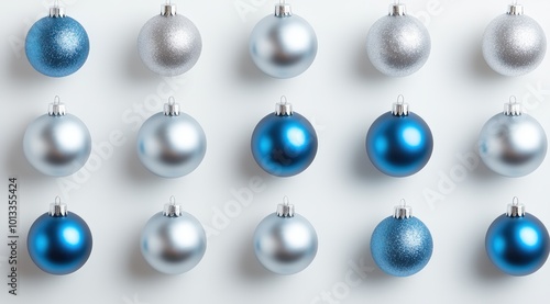 A simple flat lay of silver and blue Christmas ornaments arranged in a neat, symmetrical pattern on a white background. 