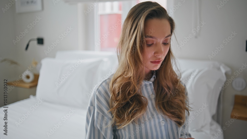 Domestic woman looking smartphone sitting home bed serious face closeup. Domestic woman looking smartphone sitting home bed serious face closeup.