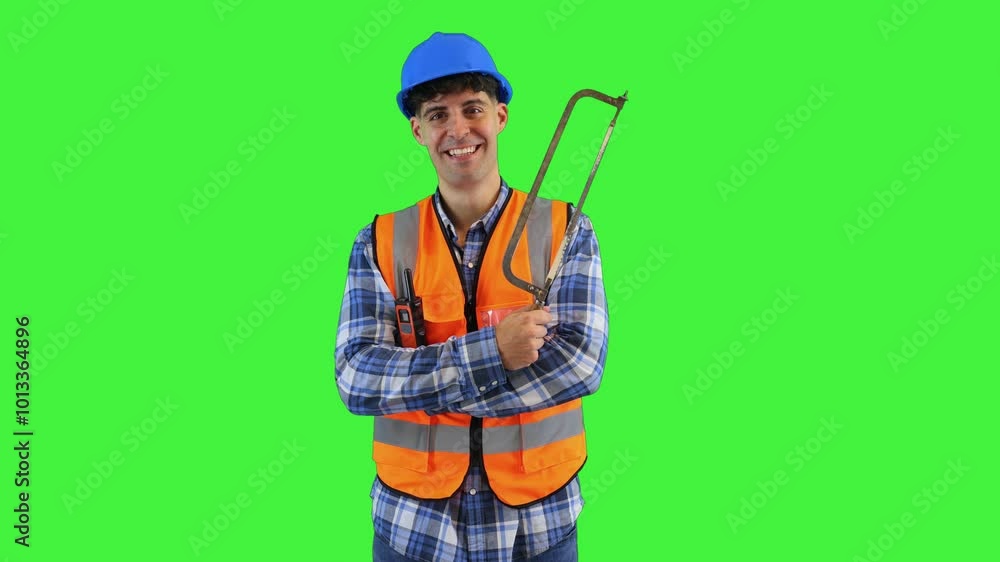 Smiling construction worker holding a hand saw ready to cut, wearing orange vest and safety helmet Smiling construction worker holding a hand saw ready to cut, wearing orange vest and safety helmet