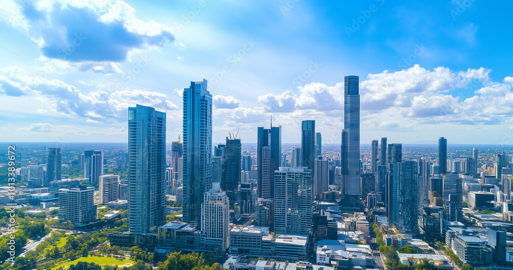 Fototapeta premium Aerial View of City Skyline and Skyscrapers Under Blue Sky and White Clouds