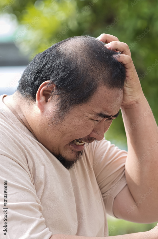 Stressful Middle Aged Asian man with Headache, concept image for Mental Stress, Sickness, Headache Pain, headache, depression or stress management Stressful Middle Aged Asian man with Headache, concept image for Mental Stress, Sickness, Headache Pain, headache, depression or stress management