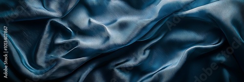 A silky, abstract blue fabric folds and waves.