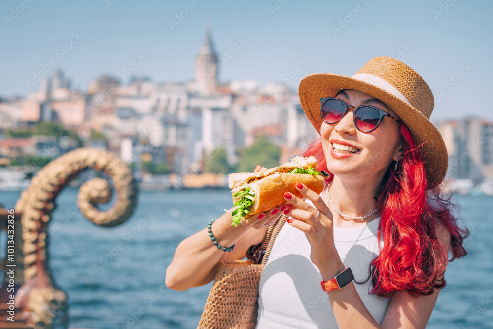 A young woman enjoys a delicious balik ekmek sandwich at a street vendor in Istanbul, savoring the fresh grilled mackerel.