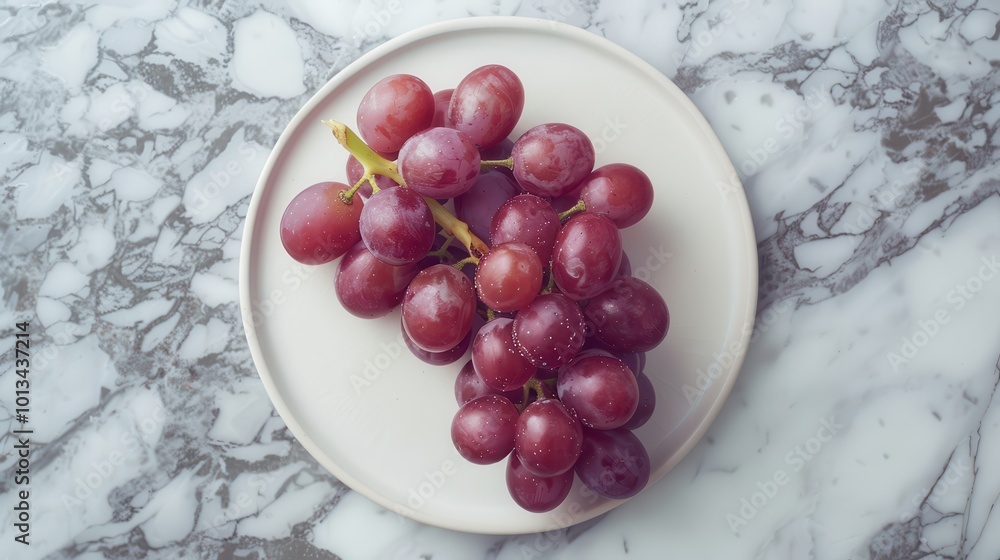 A plate of grapes is on a marble countertop