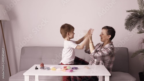 Happy mother and son giving high five. Good parenting and child relationship
