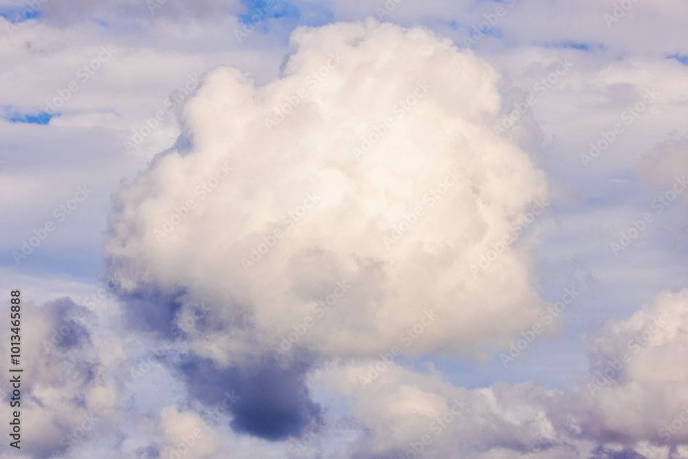 Fluffy white cloud in the sky with soft, diffused sunlight illuminating the edges. Fluffy white cloud in the sky with soft, diffused sunlight illuminating the edges.