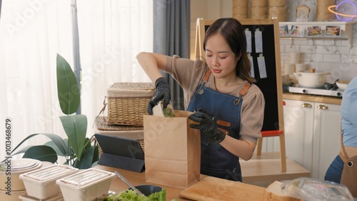 Woman preparing a healthy meal in a paper bag, showcasing homemade cooking and eco-friendly packaging in a modern kitchen. photo