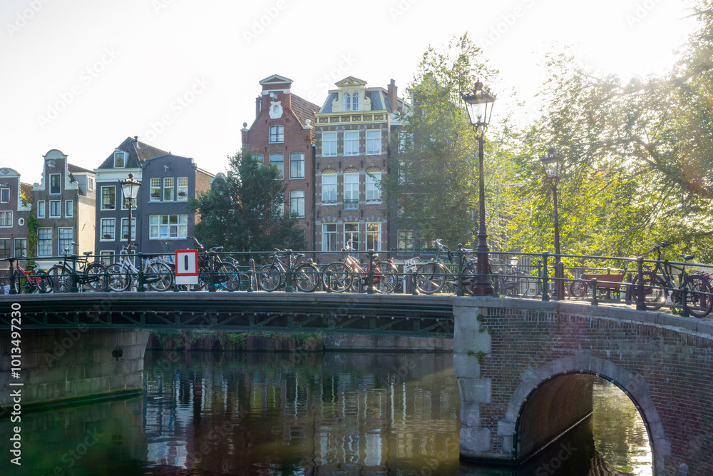 Naklejka premium Sunny Morning on an Amsterdam Canal and Bicycles