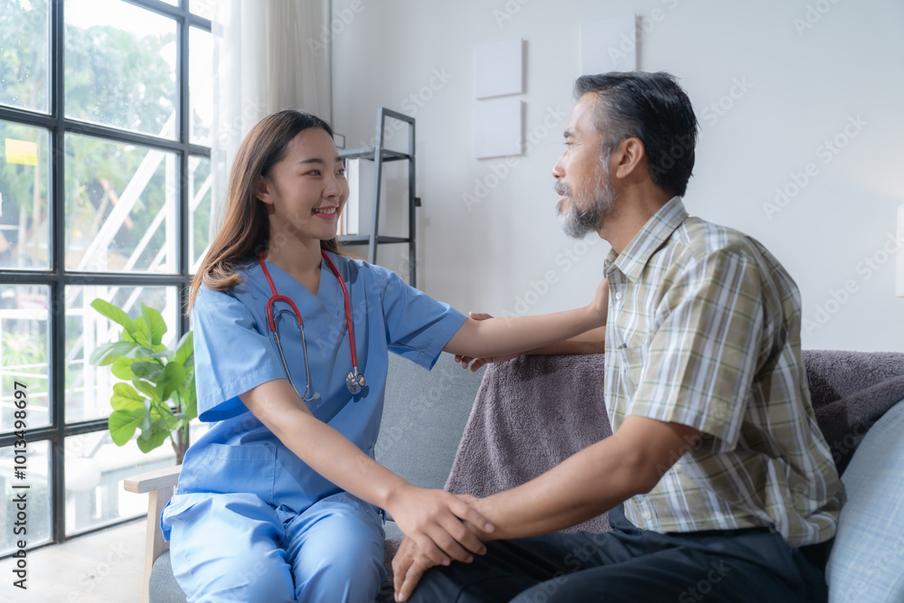 Obraz premium Young female doctor comforting a senior male patient during a home visit, showing empathy and trust in a cozy living room setting