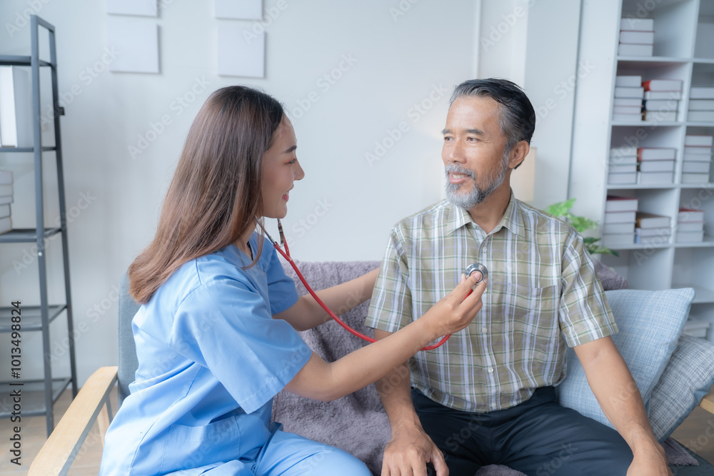 Obraz premium Young female nurse smiling while checking the heartbeat of a senior male patient with a stethoscope during a home visit