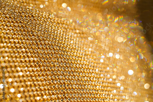 Gold lace with rhinestones shimmers, creating an impression of luxurious texture. Perfect for background or concept of elegance and wealth. Suitable for topics about fashion, jewelry, designer details