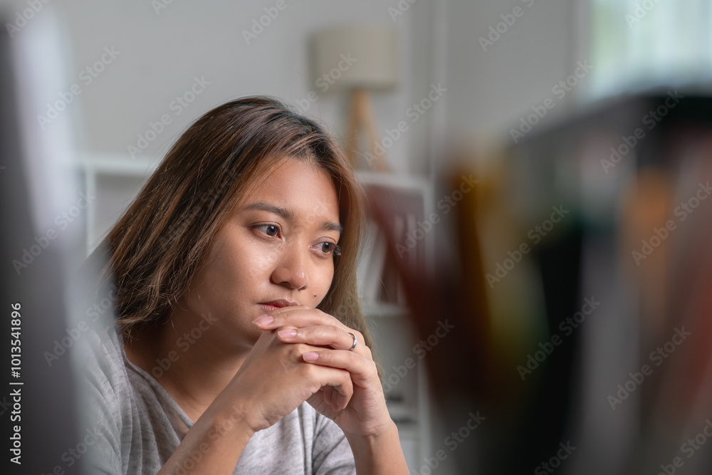 Fototapeta premium Young Asian woman sitting in a bedroom, feeling sad tired and worried suffering depression in mental health. in concept of depression anxiety and insomnia