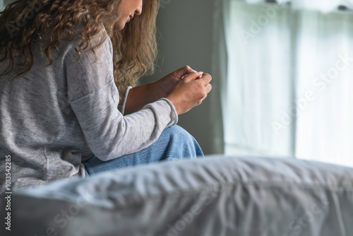 Quadro su tela Young Asian woman sitting in a bedroom, feeling sad tired and worried suffering depression in mental health