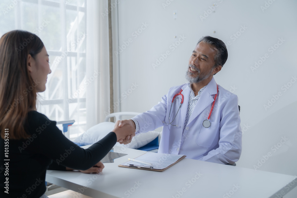 Senior doctor warmly shaking hands with a female patient in a hospital room, both smiling, showing care and trust during a consultation. A healthcare moment Senior doctor warmly shaking hands with a female patient in a hospital room, both smiling, showing care and trust during a consultation. A healthcare moment