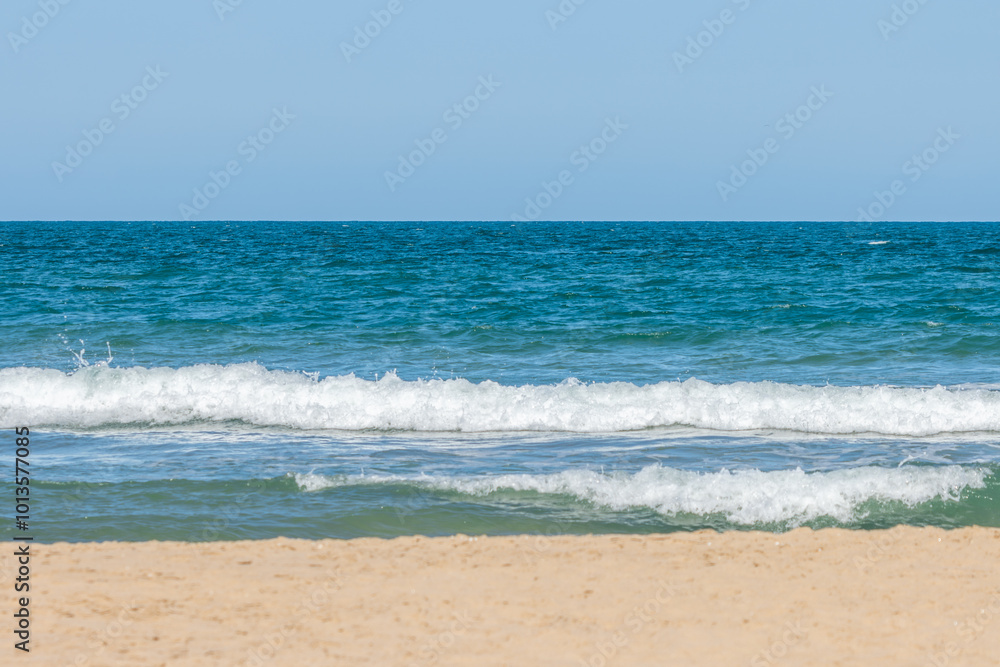 Serene Beach Scene with Clear Blue Skies and Calm Ocean Background Serene Beach Scene with Clear Blue Skies and Calm Ocean Background