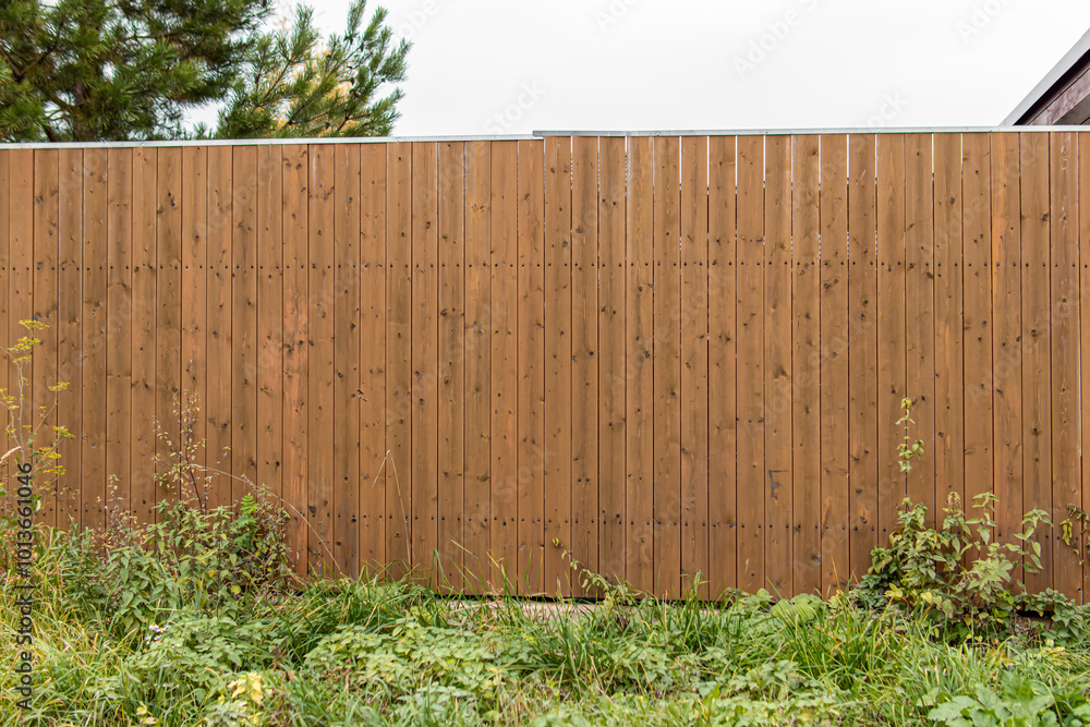 Corrugated board fence with wood texture. Decorative wooden slats Corrugated board fence with wood texture. Decorative wooden slats