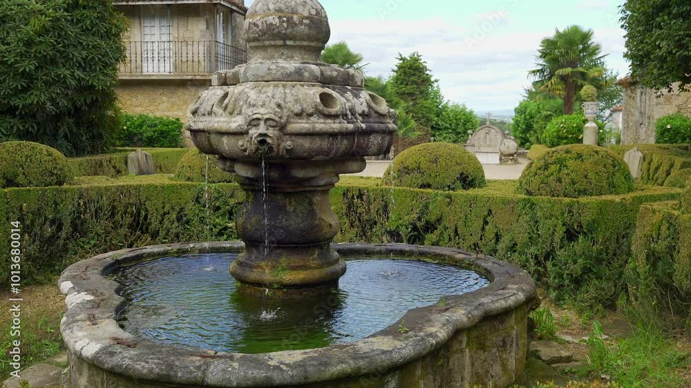 Beautiful old stone fountain with gardens around green plants, Pazo de Oca, Galicia. Beautiful old stone fountain with gardens around green plants, Pazo de Oca, Galicia.