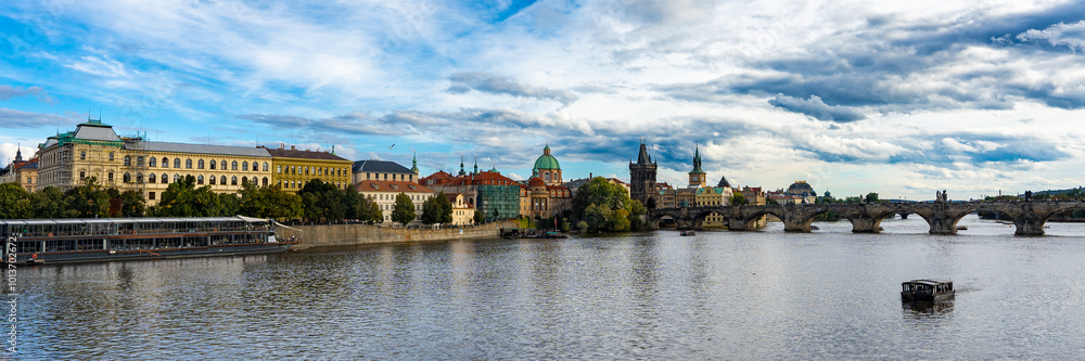 Fototapeta premium Prague, Czech Republic amazing panoramic view. World famous heritage Charles Bridge, medieval stone arch bridge that crosses the Vltava river. Bridge and embankment at autumn sunny day. 