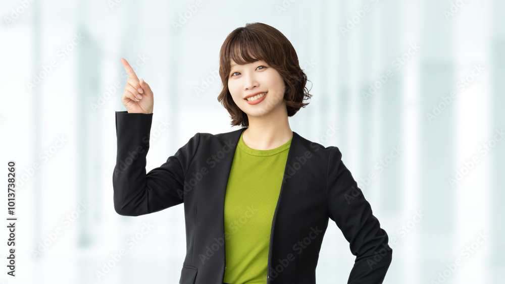 人差し指を立てて案内するビジネスウーマン