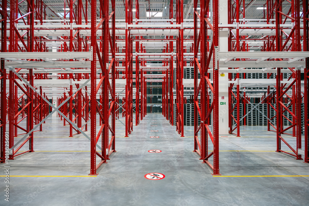 Red white racking system with grey plastic palettes inside warehouse