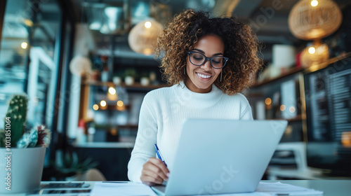 Smiling Woman Working on Laptop in Modern Office