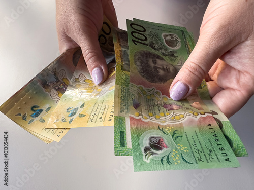 Close up rich woman count a AUD Australian dollar bills. Saving concept photo