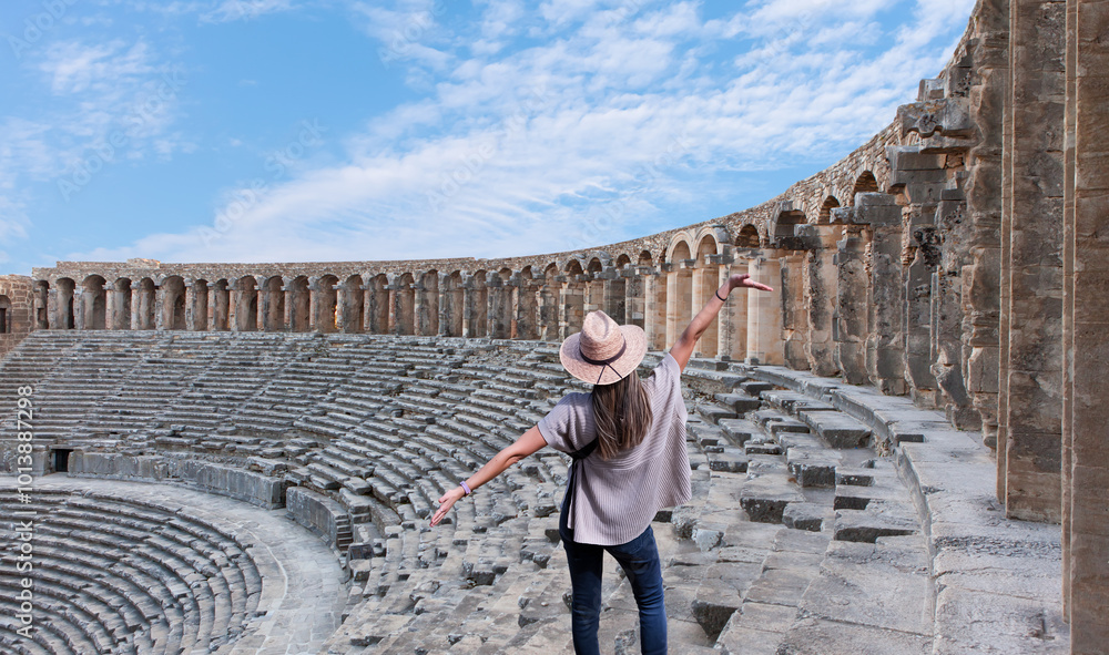Happy woman in hat open arms in free happiness standing and posing - Roman amphitheater of Aspendos, Belkiz - Antalya, Turkey Happy woman in hat open arms in free happiness standing and posing - Roman amphitheater of Aspendos, Belkiz - Antalya, Turkey