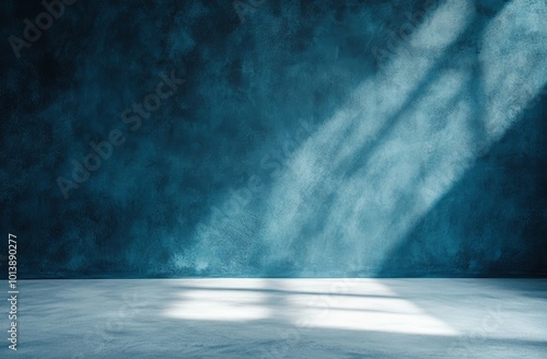 Sunlight creates dramatic shadows on a textured blue wall and floor, enhancing the tranquil atmosphere of the studio space photo