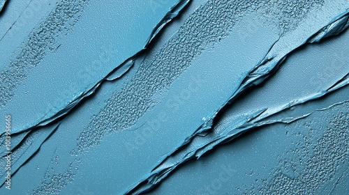 Abstract close-up of a textured blue surface, showcasing layers and patterns created by paint or plaster.
