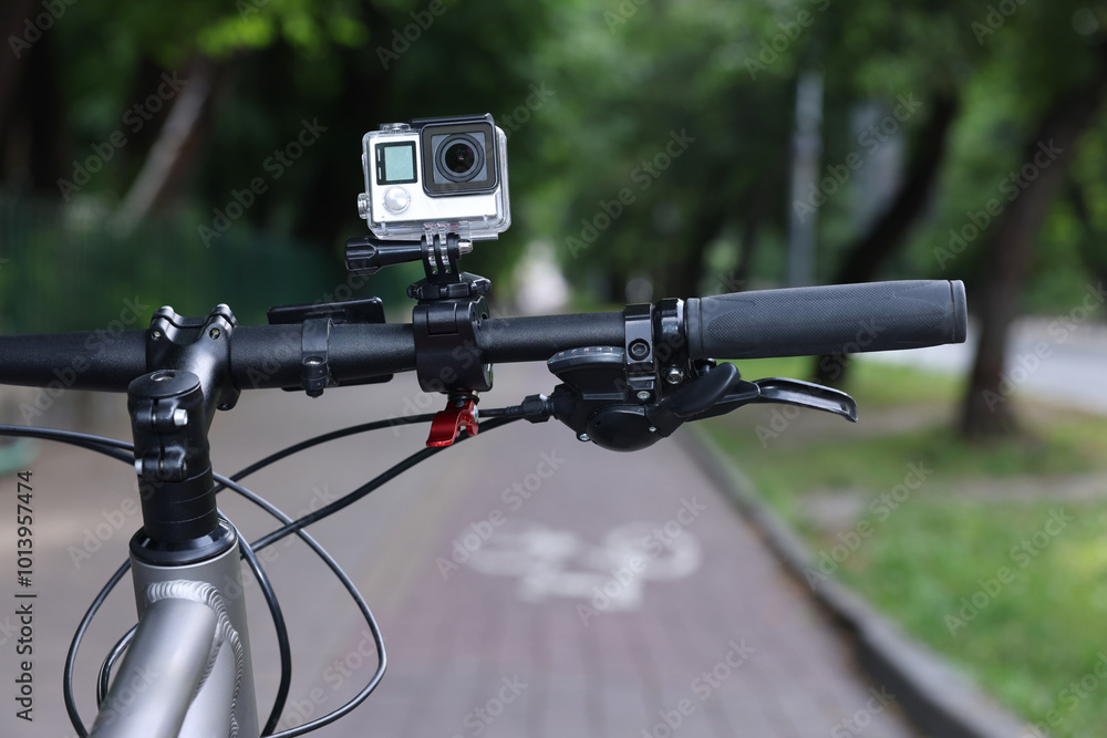 Modern action camera with mount on bicycle outdoors, closeup Modern action camera with mount on bicycle outdoors, closeup