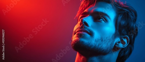 A captivating portrait of a young man illuminated by dramatic blue and red lighting, showcasing emotion and intensity.