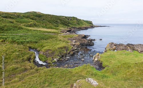 A magnificent waterfall on the Isle of Mull cascading gracefully into the glistening sea below. photo