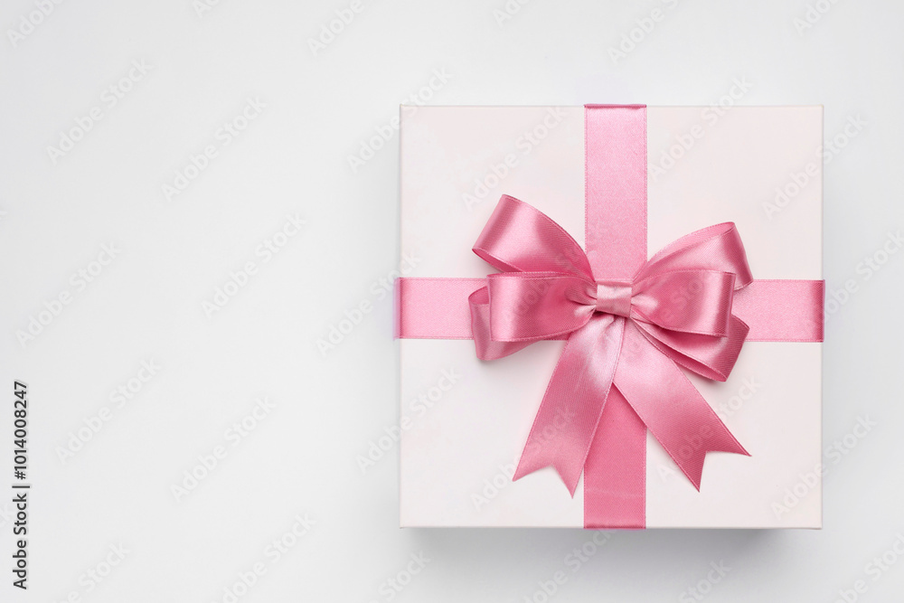 Gift box with pink bow on light grey background, top view. Space for text Gift box with pink bow on light grey background, top view. Space for text