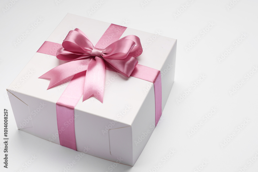 Gift box with pink bow on light grey background. Space for text Gift box with pink bow on light grey background. Space for text