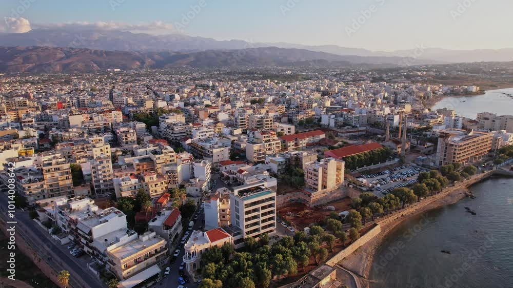Aerial view of a coastal city with mountains under a clear sky at sunset Aerial view of a coastal city with mountains under a clear sky at sunset