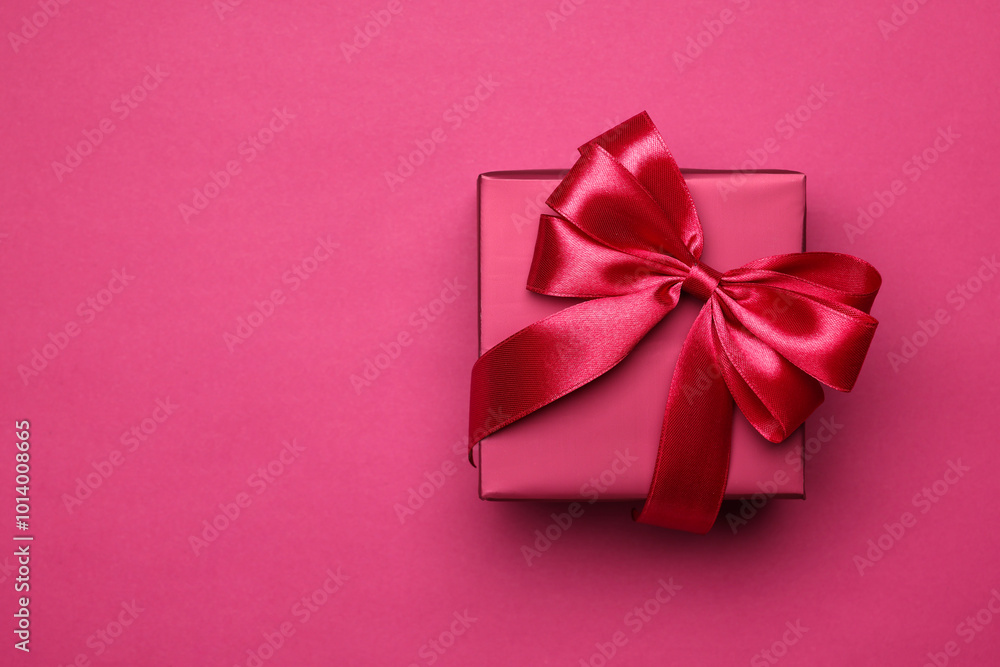 Gift box with bow on pink background, top view. Space for text Gift box with bow on pink background, top view. Space for text