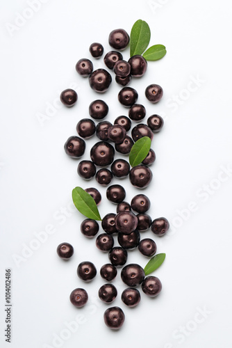 Ripe acai berries and leaves on white background, flat lay photo