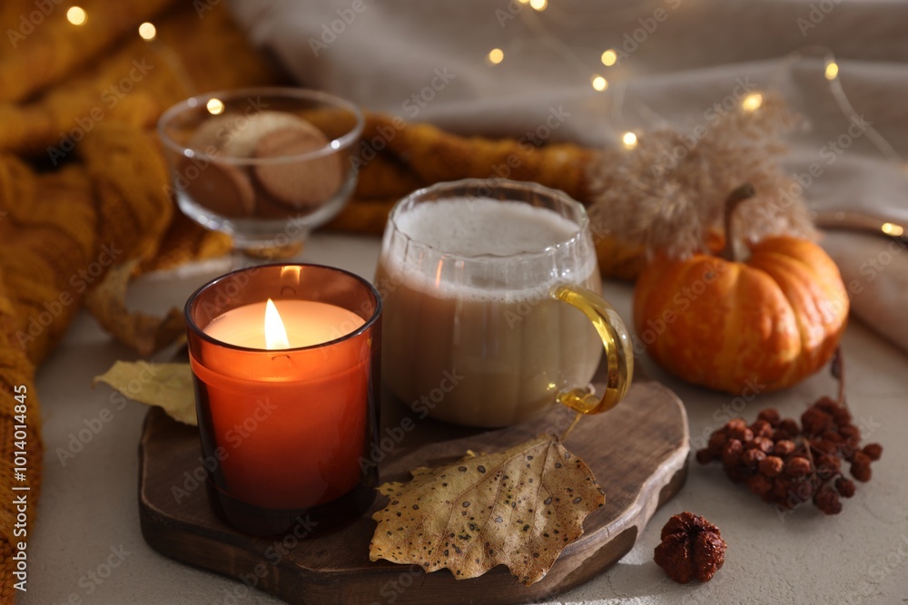 Burning candle, cocoa and autumn decor on light table. Cozy atmosphere Burning candle, cocoa and autumn decor on light table. Cozy atmosphere