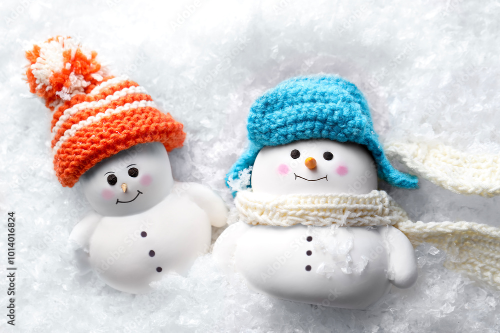 Cute decorative snowmen on artificial snow, top view Cute decorative snowmen on artificial snow, top view