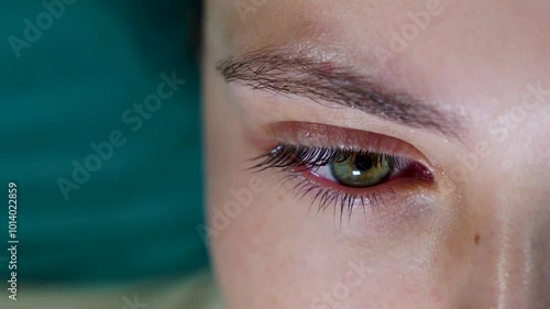 Close up of human eye with water drops falling on eyelashes and eyelid. Macro shot of eye care, ophthalmology examination, vision health, hydration and skincare concept. Design for medical, healthcare