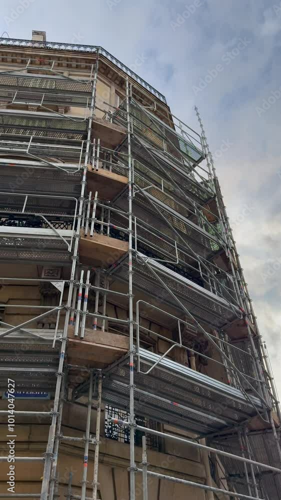 Un immeuble parisien en travaux, entouré d'un échafaudage au format vertical. Un immeuble parisien en travaux, entouré d'un échafaudage au format vertical.
