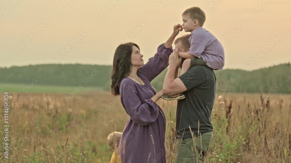 portrait of a family, a happy beautiful pregnant woman mother with two children and her husband father of Slavic appearance in the summer on a walk at sunset close-up. High quality portrait of a family, a happy beautiful pregnant woman mother with two children and her husband father of Slavic appearance in the summer on a walk at sunset close-up. High quality
