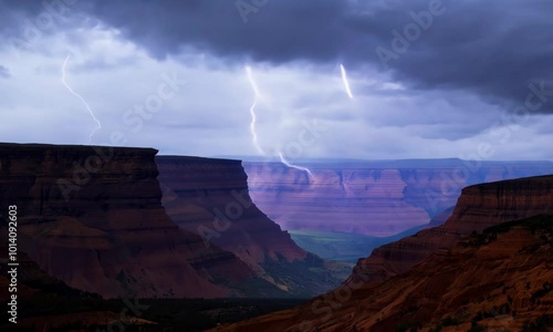 Orange lightning illuminating storm clouds over a deep canyon. Video