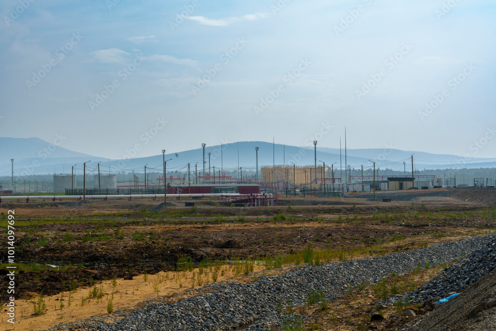 Remote construction site with dirt road and distant mountains Remote construction site with dirt road and distant mountains