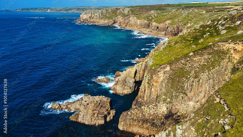 Fototapeta premium Rugged Coastal Cliffs Overlooking Clear Blue Waters in Cornwall, UK