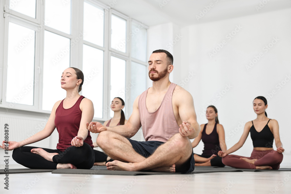 Group of people meditating on mats in yoga class Group of people meditating on mats in yoga class