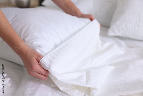 Woman changing clean bed linens at home, closeup