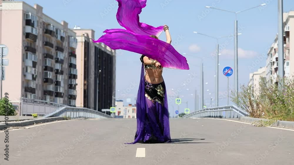 Young beautiful girl dancing oriental dances against the backdrop of the city Young beautiful girl dancing oriental dances against the backdrop of the city