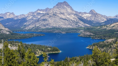 A scenic view of a mountain range with a large blue lake in the foreground.