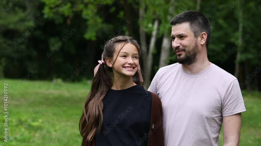 Young father with teenage daughter posing in summer park Young father with teenage daughter posing in summer park